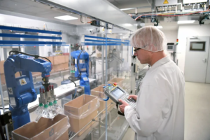 A man operating a robot to fill packages